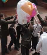 Use a few students to prepare the balloon. Make sure the sides are well clear of the flame.