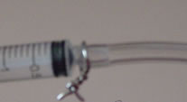 The syringe with wire wrapped around the nozzle.